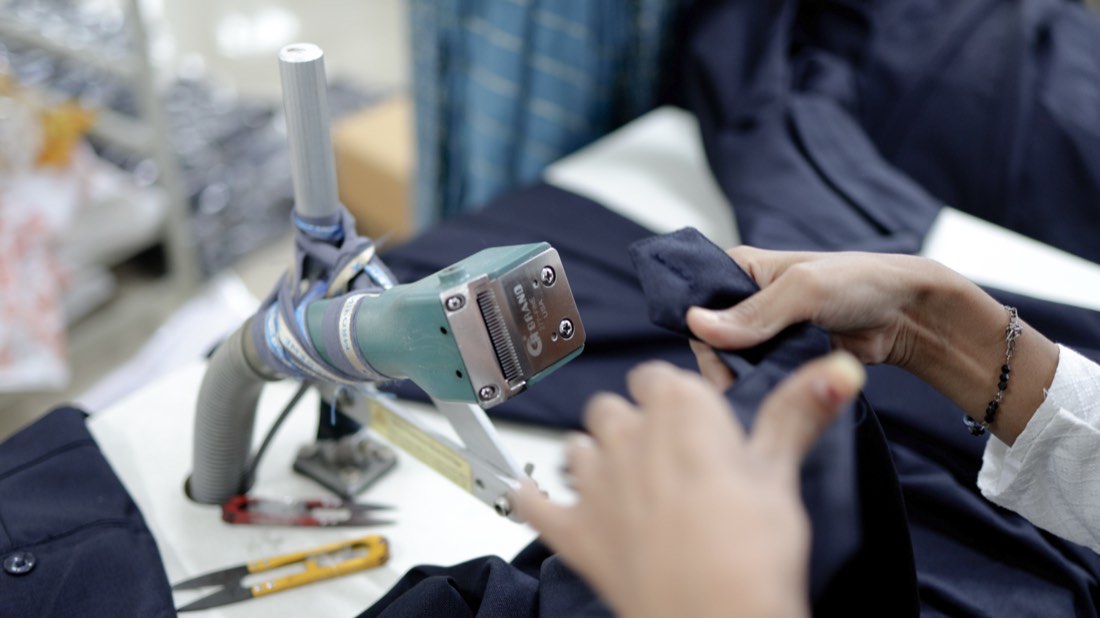 A finished garment being passed under a hand-held checking device