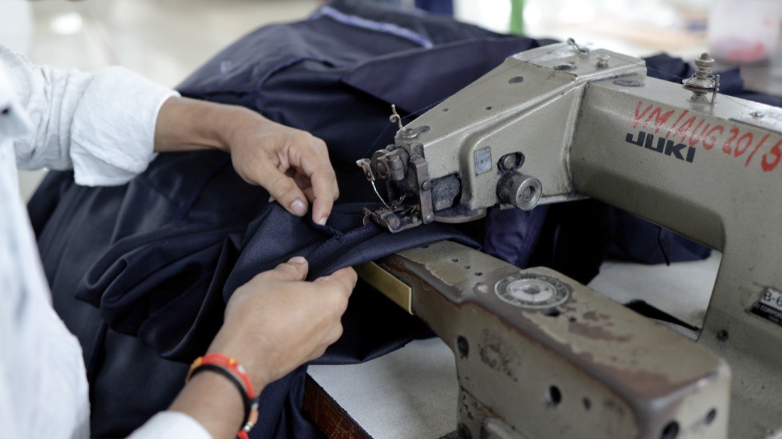 A finished garment being folded by hand