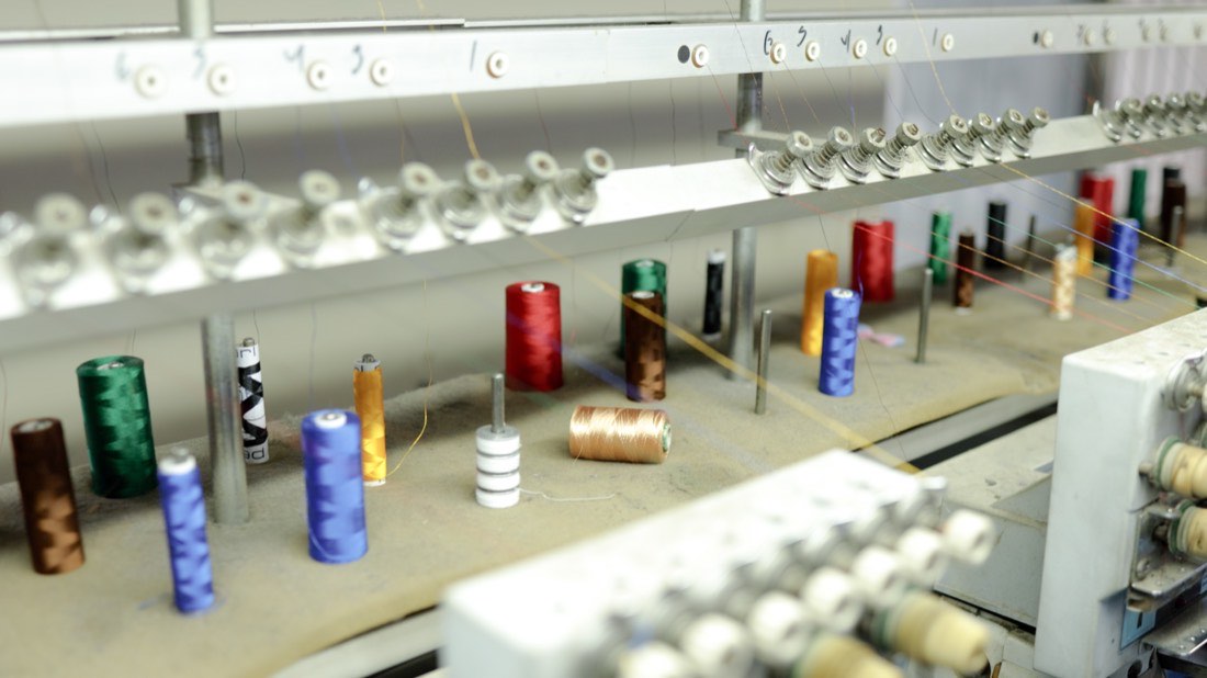 Racks of coloured thread above the machines
